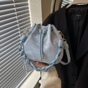 Light blue drawstring bucket bag with marble texture and woven handle for women