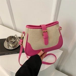 Pink and beige woven crossbody bag with adjustable strap and golden buckle detail