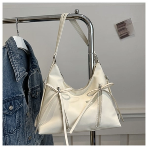Detail of off-white PU leather tote with vertical zippers and bow ribbon decorations