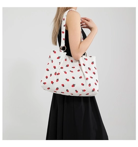 Detail of white corduroy tote bag with strawberry prints and metal ring buckle