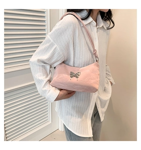 Detailansicht der rosa Tasche in Knitteroptik mit silbernem Schmetterling aus Metall
