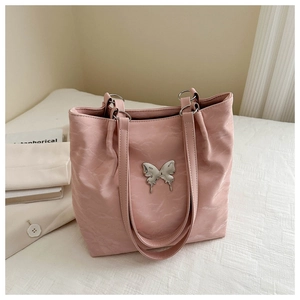 Détail du sac cabas rose avec relief papillon argenté et texture plissée douce