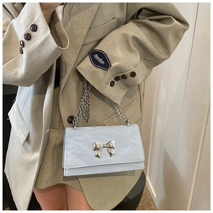 Détail du sac bleu clair avec boucle nœud argenté et texture en cuir travaillé