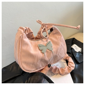 Détail du sac plissé rose avec breloque papillon argentée et bandoulière froncée chic