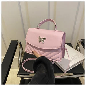 Detailed view of pink quilted crossbody bag with silver butterfly metal clasp buckle