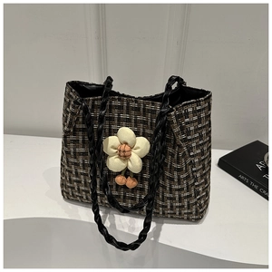 Dettaglio borsa tote in tweed con manici in corda di pelle e grande ciondolo a fiore