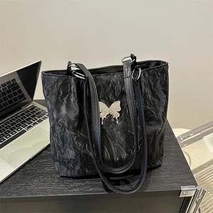Sac fourre-tout noir minimaliste avec texture froncée et papillon en métal argenté