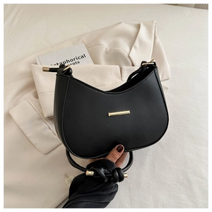 Macro shot of black hobo bag with knotted strap and minimalist gold metal detail