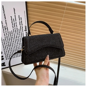 Detailed close-up of a black sequin crossbody bag featuring gold-toned hardware and texture