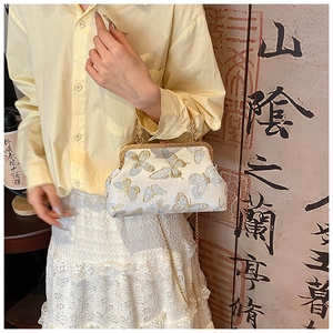 Détail du sac à bandoulière en soie avec broderie papillon et fermoir doré chic