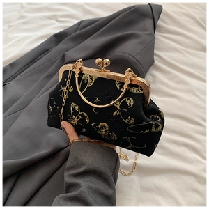 Detalle de bolso de noche vintage negro con bordado de mariposas doradas