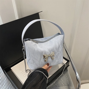 Light blue pleated crossbody bag with silver bow accent and metal chain strap