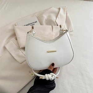 Minimalist white crescent shoulder bag with knotted rope handle and gold metal detail