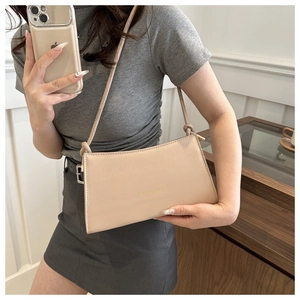 Détail d'un sac bandoulière beige rectangulaire avec lettrage doré Fashion élégant