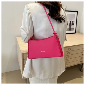 Sac sous le bras rose rouge au design minimaliste avec des détails dorés sphériques