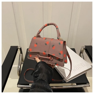 Detail van lavendelkleurige mini-handtas met aardbeienprint en afneembare schouderriem
