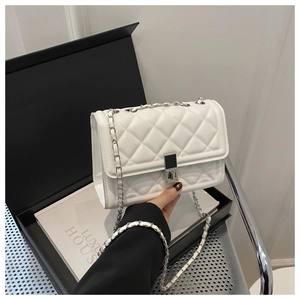 Détail du sac à bandoulière matelassé blanc avec fermoir argenté et texture cuir de luxe