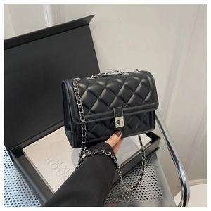 Détail du sac à bandoulière matelassé noir avec chaîne argentée et fermoir en métal