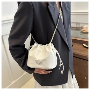 Close-up of white drawstring bucket bag with metal chain strap and triangle logo detail
