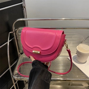 Schicke magentafarbene Satteltasche mit Wellenklappe und goldener Schließe, Lifestyle-Look