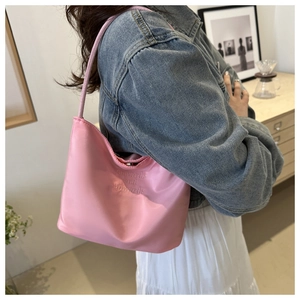 Detail of pink satin shoulder bag featuring embossed onwards and upwards text