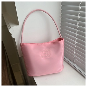 Detail of pink nylon shoulder bag with embroidered onwards and upwards motivational text
