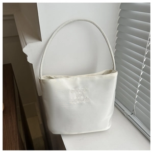 Detail of white bucket bag with onwards and upwards embroidery on premium fabric