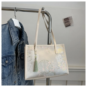 Détail d'un sac cabas beige avec broderie chinoise traditionnelle, bambous et fleurs