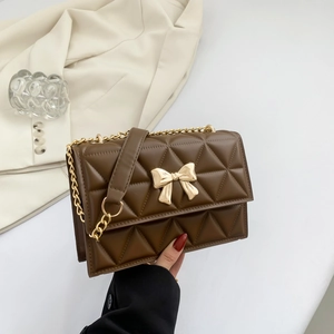 Brown quilted crossbody bag with gold bow clasp and metal chain strap shown at 45 degrees