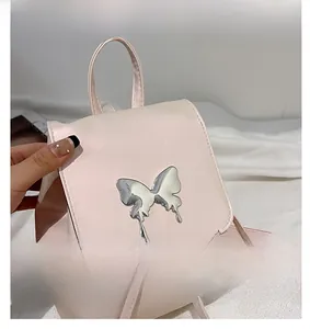 Close-up of silver metal butterfly accent on light pink faux leather backpack detail