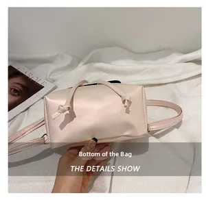 Detail view showing the flat rectangular bottom of the minimalist light pink leather backpack