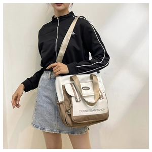 Detailansicht der Canvas-Tasche mit Farblock-Design, verstellbarem Gurt und Fronttasche