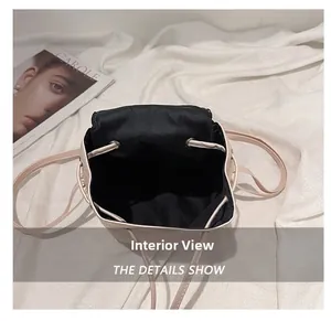 Internal compartment view of beige drawstring backpack with black lining and metal eyelets
