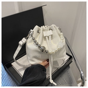 Vue détaillée du sac seau blanc perle avec poignée perlée et cordon de serrage argenté