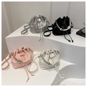 Détail de mini sacs seaux colorés avec poignées en perles et cordon de serrage