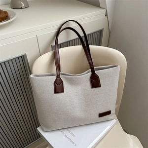 Large capacity canvas tote bag with brown leather handles for women's daily commute