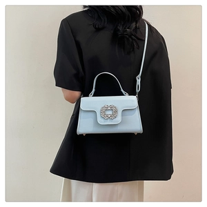 Détail du sac bandoulière bleu clair avec une grande boucle carrée en cristal brillant