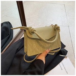 Detail of light green bag showing marble texture and trendy cylindrical knotted handle