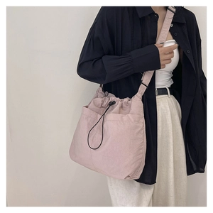 Detail of light pink drawstring bucket bag with side pockets and durable nylon texture