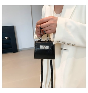 Detail of a mini black shiny leather handbag showing the silver twist lock and studs
