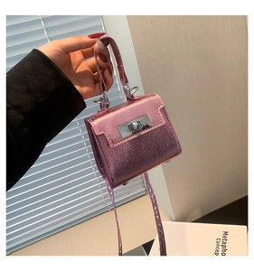 Macro detail of mini Kelly-style crossbody bag in metallic pink glitter finish with silver clasp