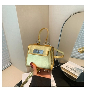 Detail of mini gold metallic handbag with silver turn-lock and hand-held demonstration