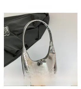 Gros plan sur la texture crocodile argentée et le double zip du sac à main chic