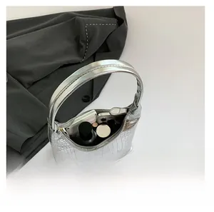 Vue intérieure du sac argenté à motif crocodile montrant l'espace pour téléphone et maquillage