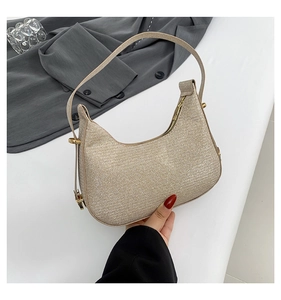 Close-up of champagne gold sequin fabric texture and metal buckle on woven shoulder bag