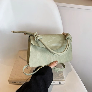 Elegant mint green textured crossbody bag with rope handle and gold metal hardware