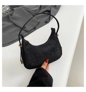 Close-up of black sequined crescent bag with premium gold metal hardware and zipper detail