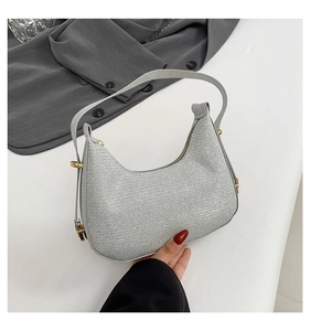 Detail of silver sequin hobo bag showing sparkling texture and gold buckle hardware