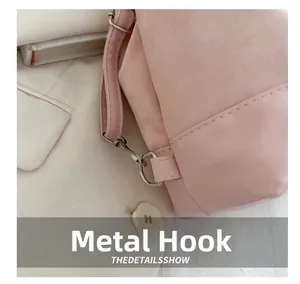 Detail of pink bucket bag featuring metallic silver hooks and premium stitching texture