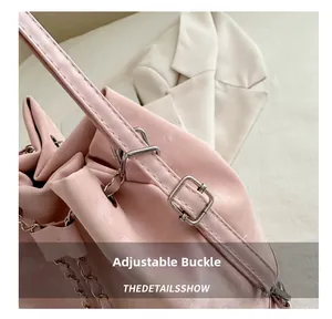 Detailed view of pink leather bag with silver adjustment buckle and metal chain strap